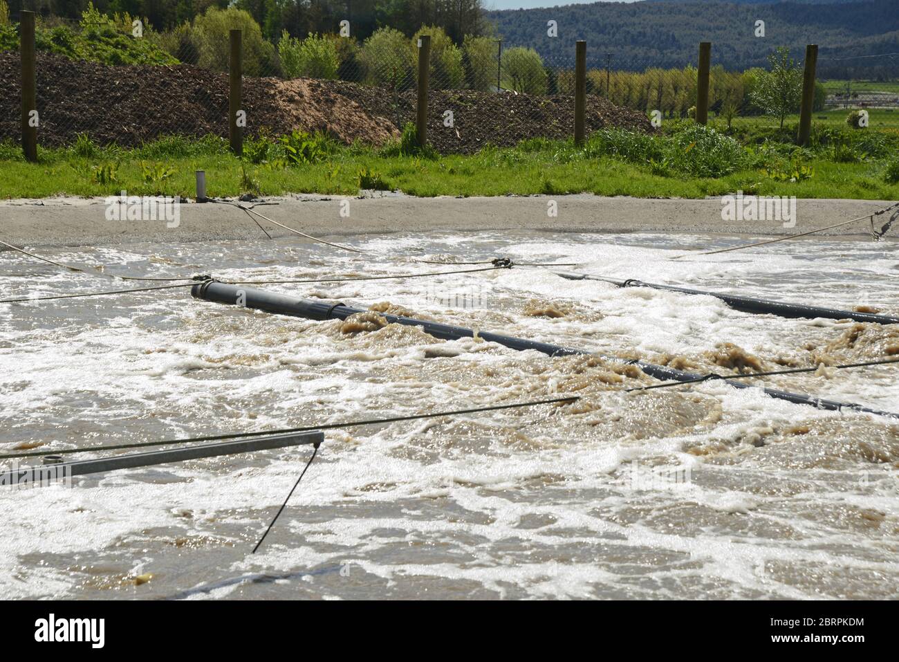 A holding pond uses aeration to remove pollutants from industrial waste water Stock Photo