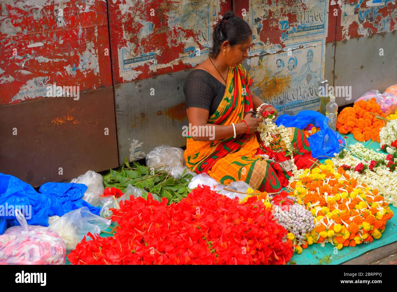 A woman selling flowers by the roadside. Stock Photo