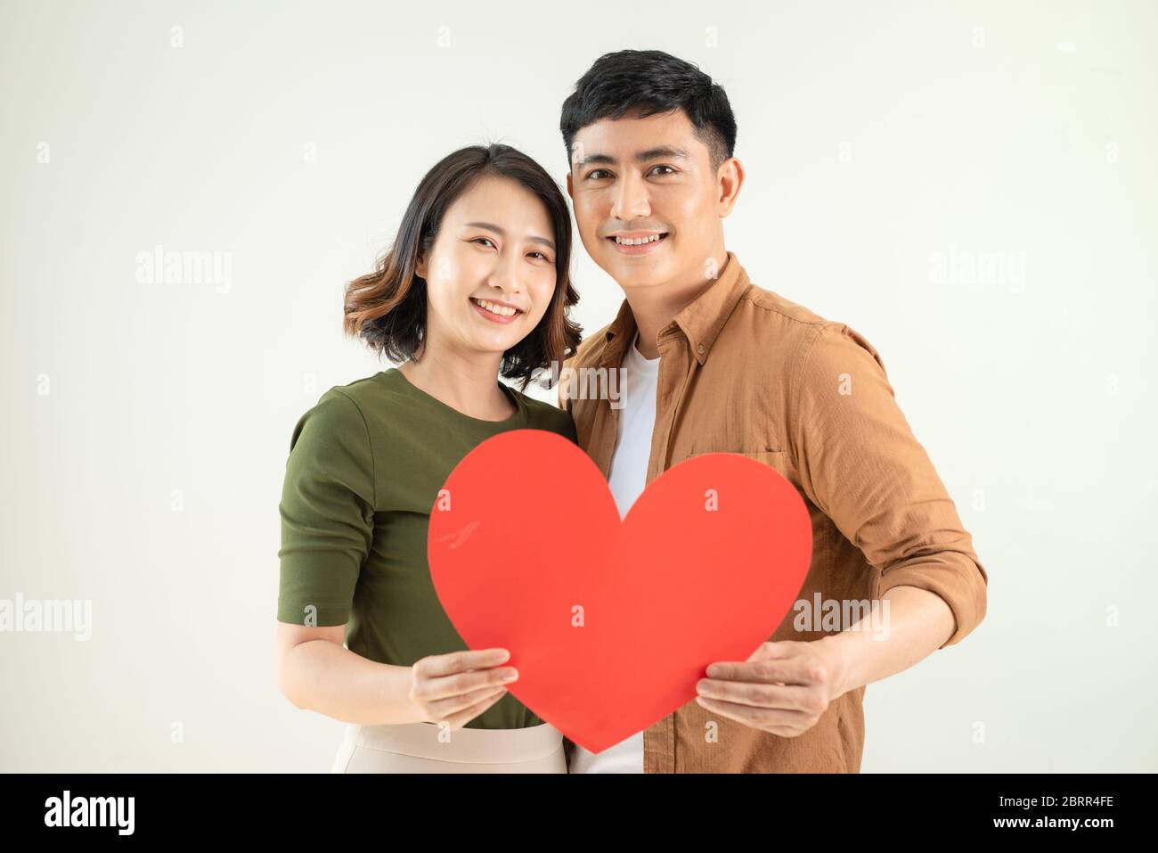 Smiling loving couple holding heart shape over white background Stock ...