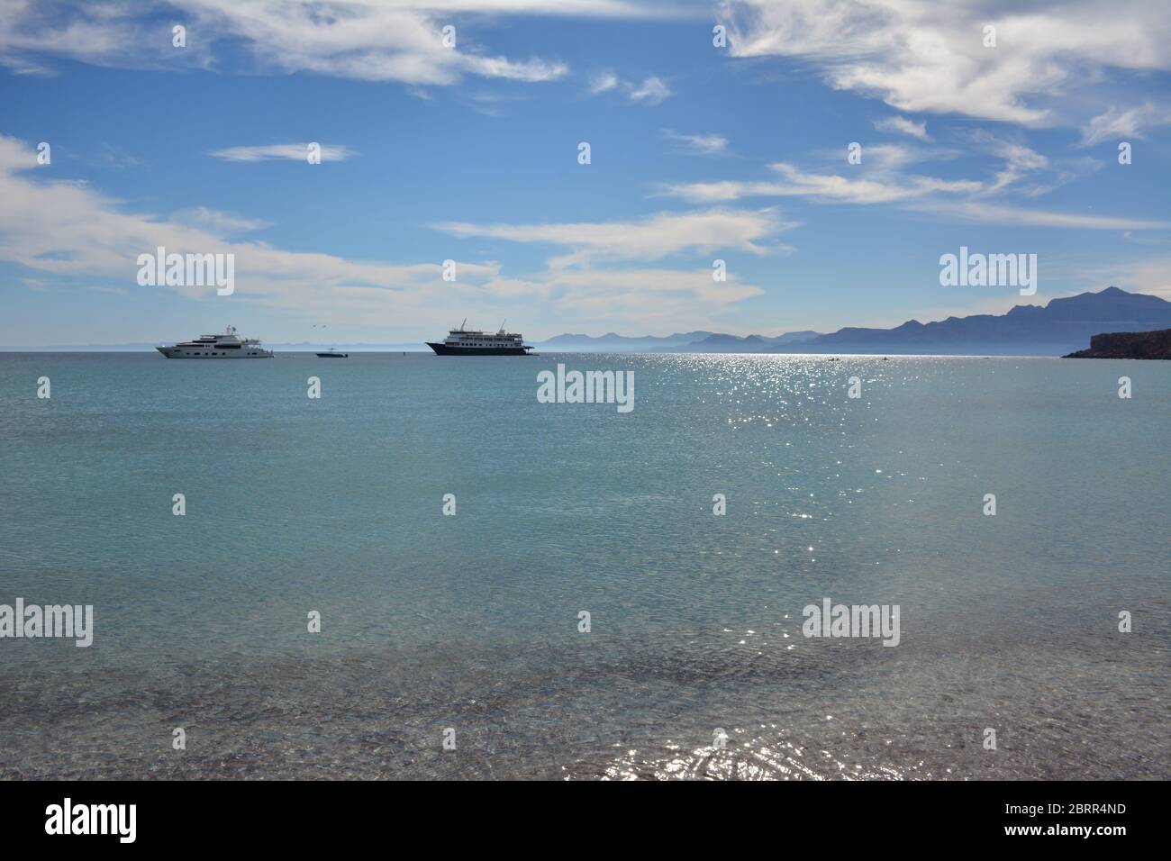 Clear glittering sea with a cruise ship and yacht in the background at Isla San Francisco, Sea of Cortez, Baja California Sur, Mexico. Stock Photo