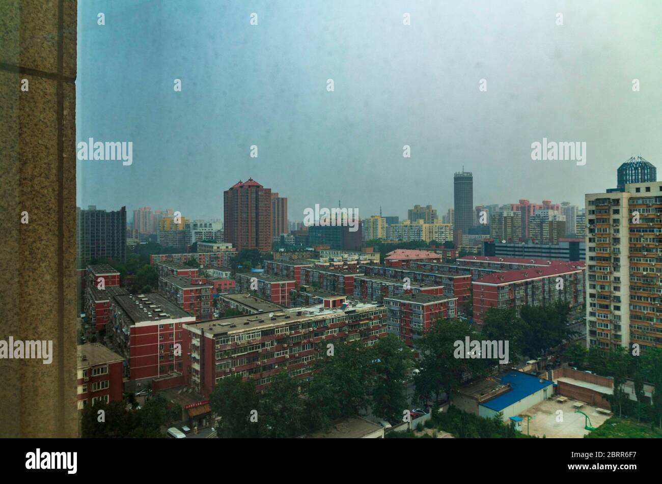 Beijing China Shoot through dirty glass from a hotel room overlooking the city on a overcast day Stock Photo
