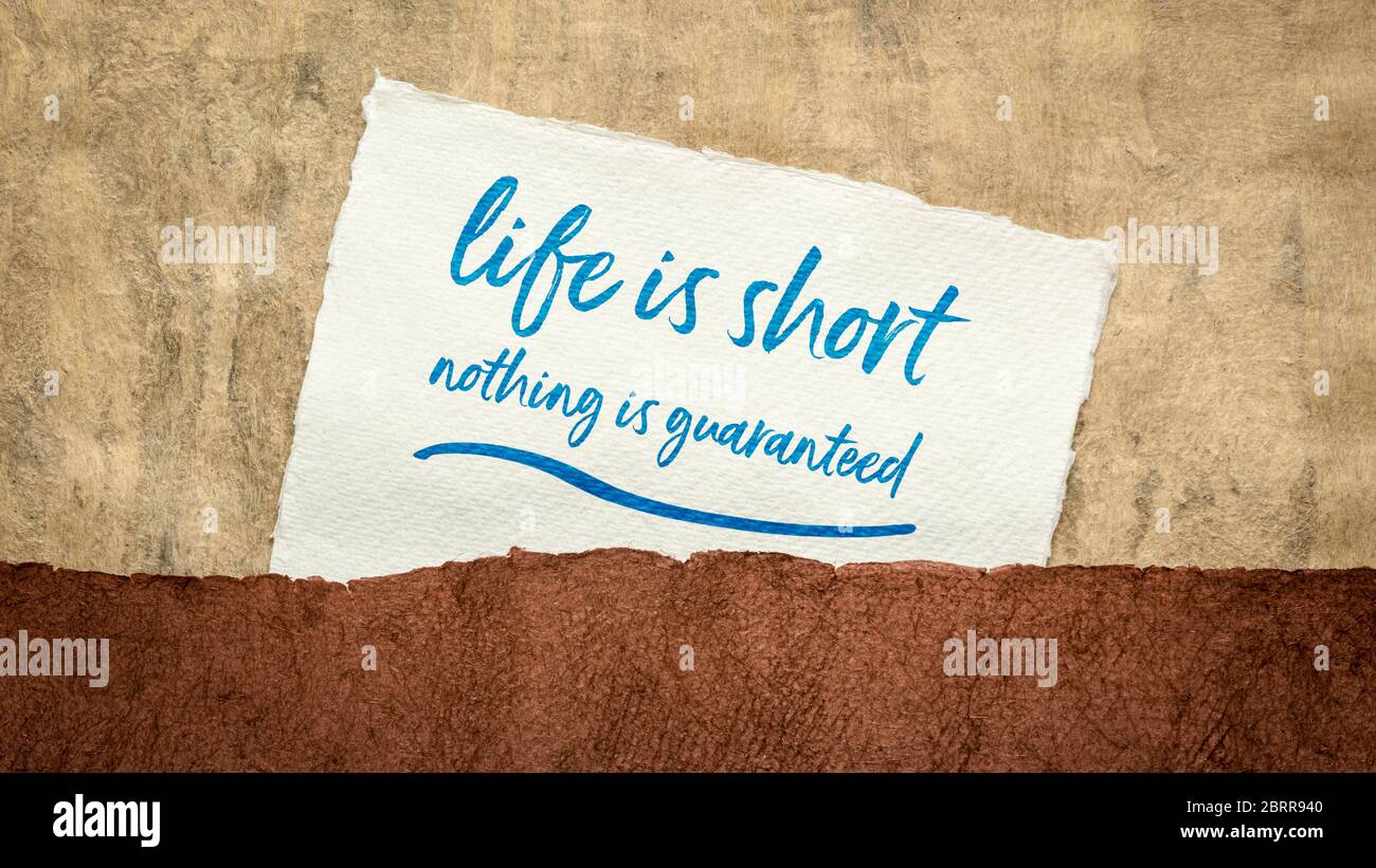 life is short, nothing is guaranteed inspirational reminder - handwriting on a handmade textured paper Stock Photo