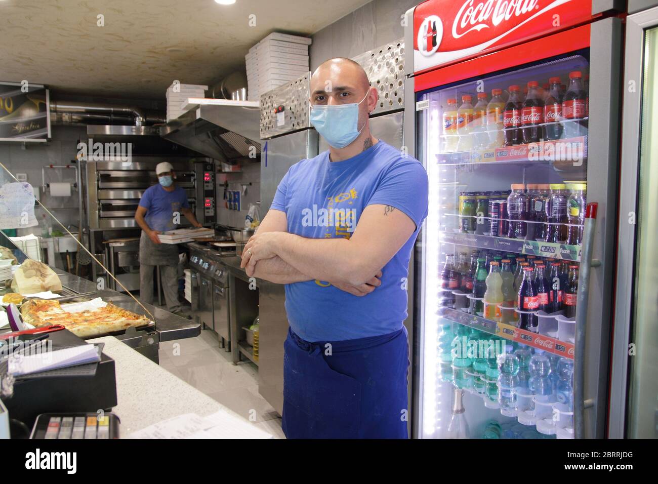 The owner of a deli and pizzeria to take away in his premises to the reopening of the commercial activity during the phase 2 of the emergency Stock Photo