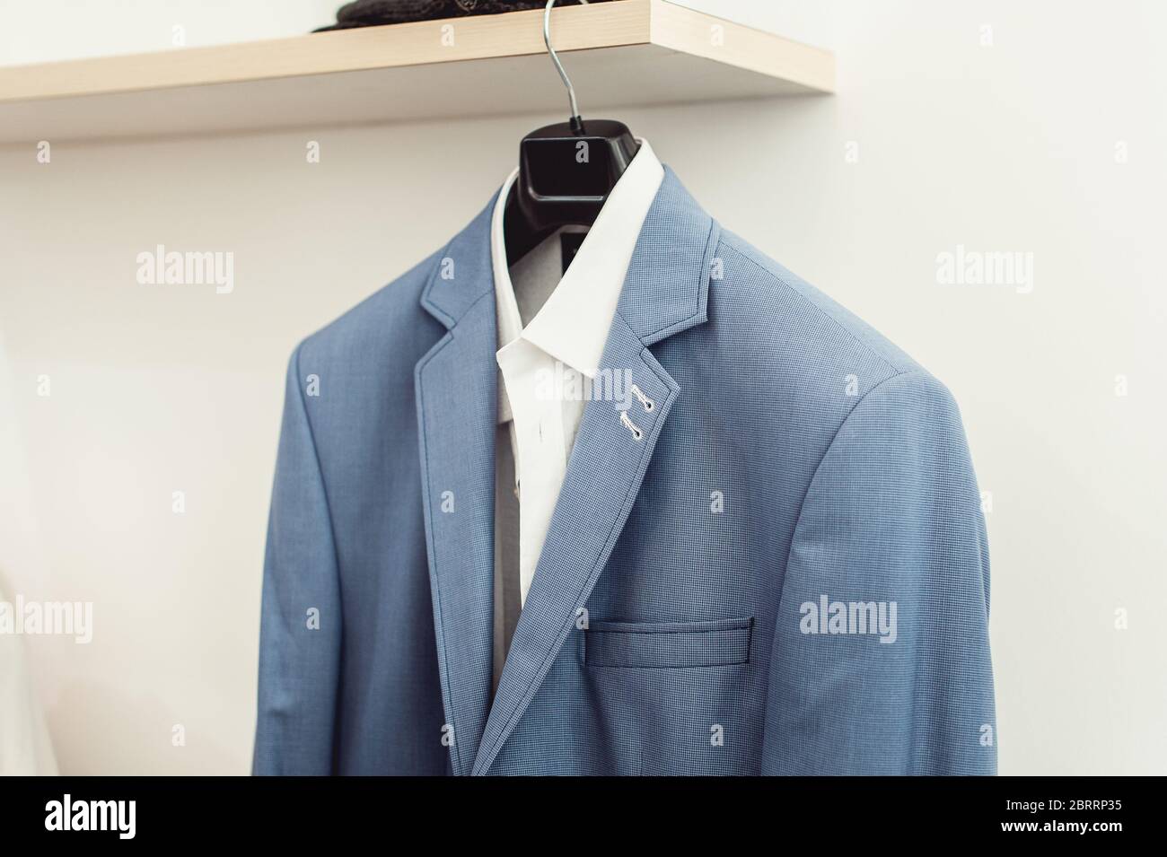 blue suit jacket with a white shirt on the rack Stock Photo Alamy