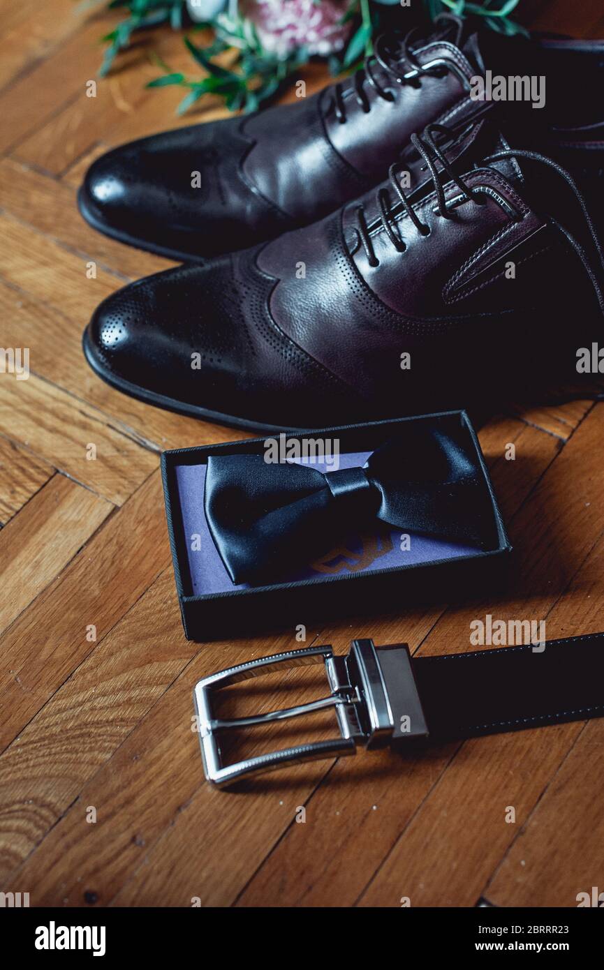 Close up of modern man accessories. Black bowtie, leather shoes