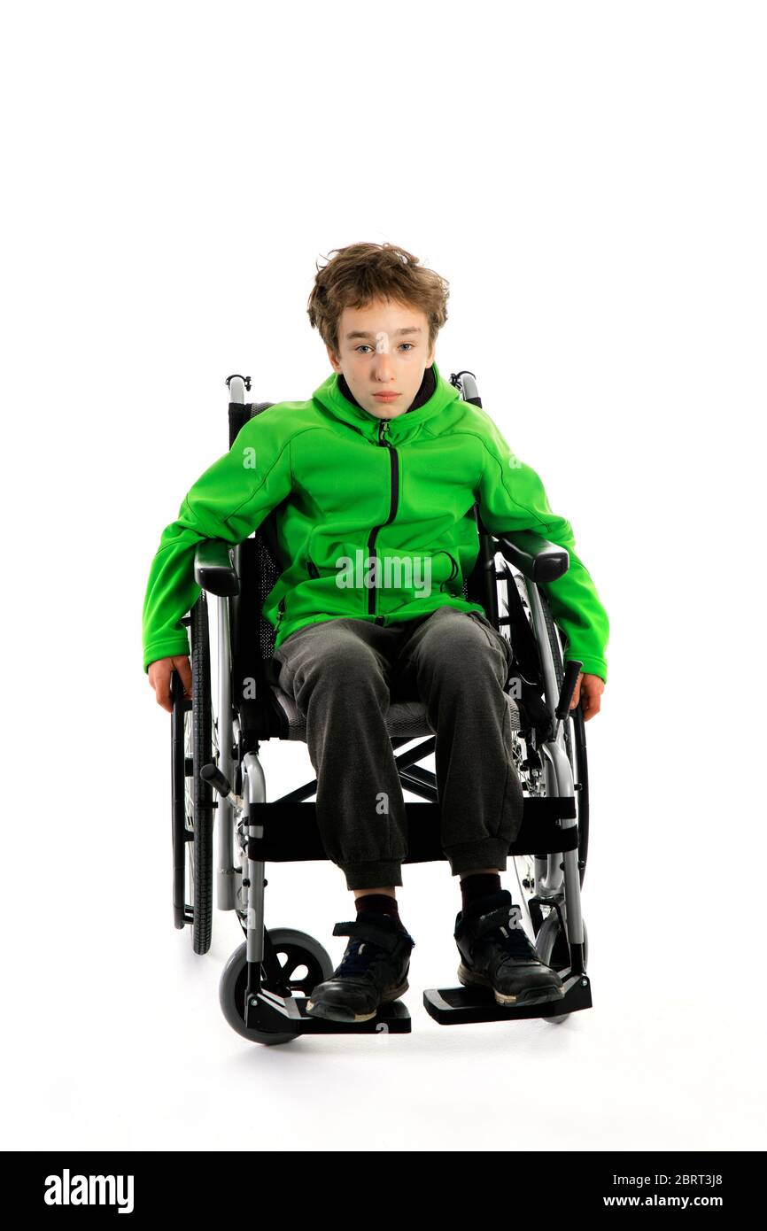 Little boy in wheelchair on white background , boy is sitting in a wheelchair on a white background. Hospital patient with disability Stock Photo