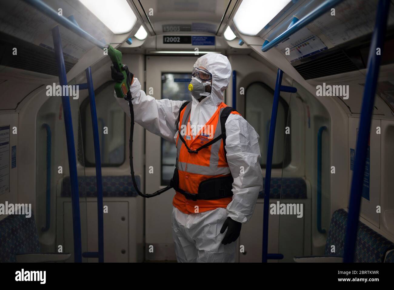 TfL worker Noureddine Aouf sprays anti viral solution Zoono-71 inside a Victoria Line tube train at the London Underground Northumberland Park Depot in Tottenham, north London. Stock Photo