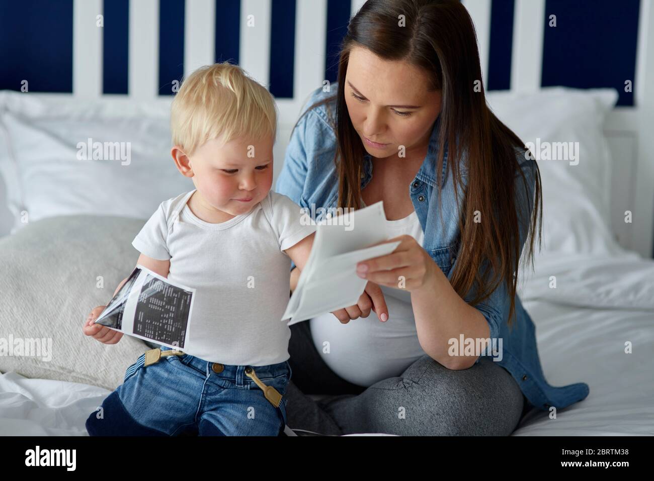 Pregnant woman browsing ultrasound images with her offspring Stock Photo