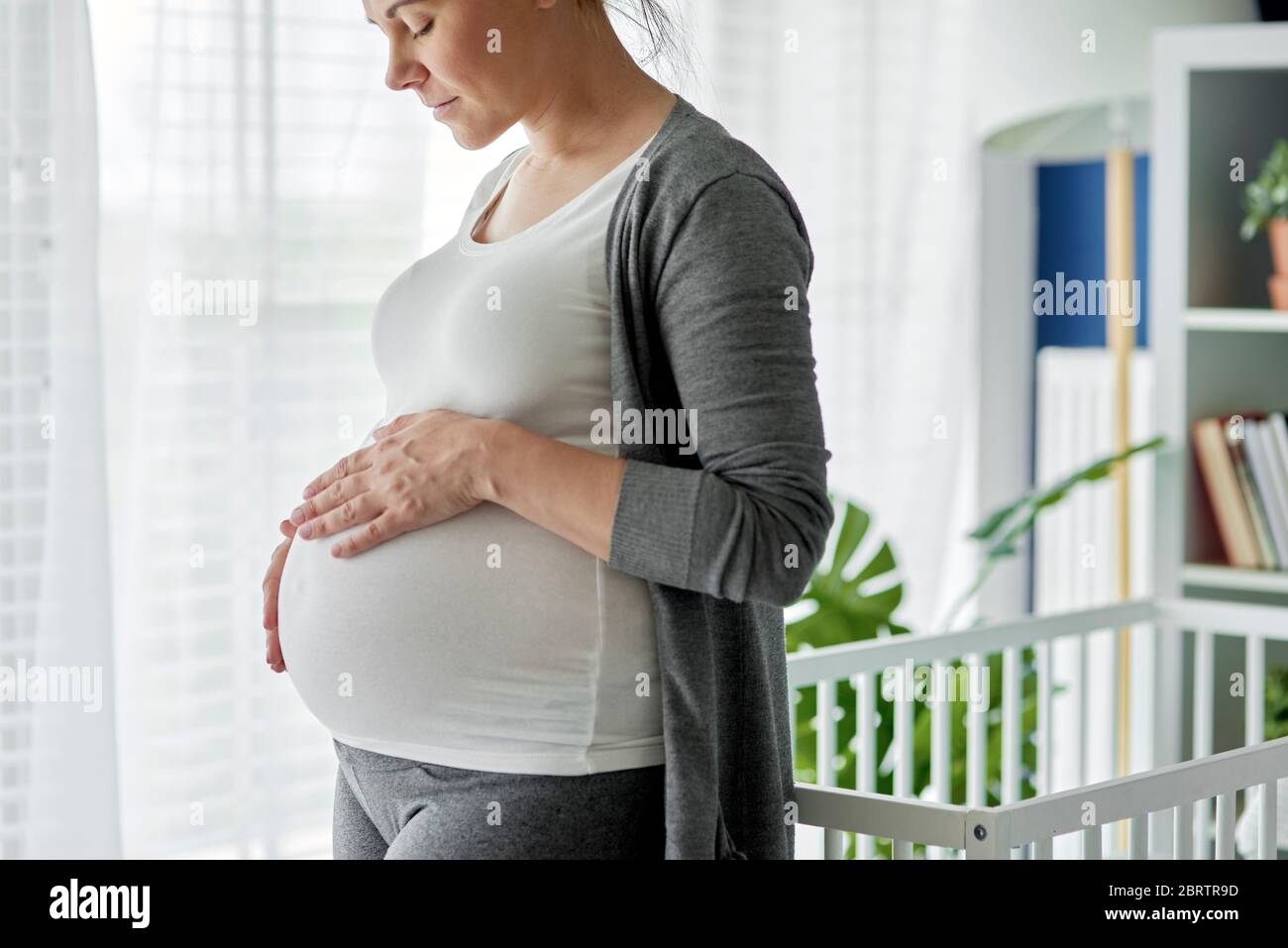Pregnant woman strobing her big abdomen Stock Photo