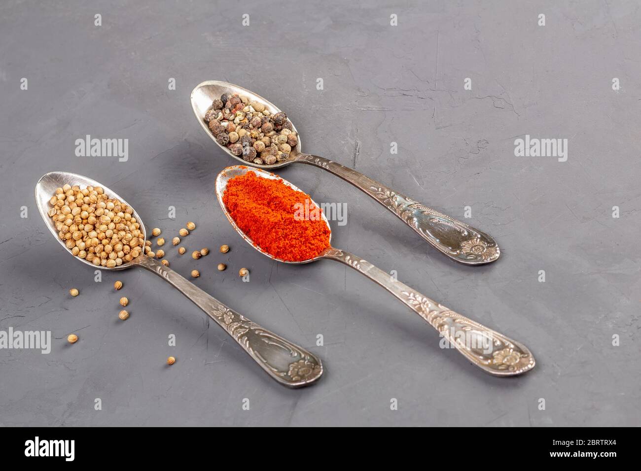 Closeup coriander seeds and ground paprika and black pepper peas in