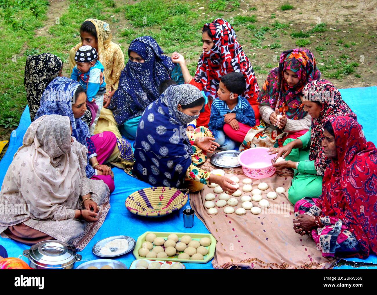 Pashtun community are busy preparing meals to break the fast during the holy month of Ramadan in a unique way on the outskirts of Anantnag District in Indian Administrated Kashmir. Before the Indian subcontinent was divided and the newly nations India and Pakistan came into existence this community used to come for trade. Many of them settled in Kashmir. The Pashtuns of Kashmir have their ancestral roots in Pakistan and Afghanistan. They have been living in Kashmir since more than a decade. There are about 80 thousand people of this community in different areas of Kashmir and we traveled to t Stock Photo