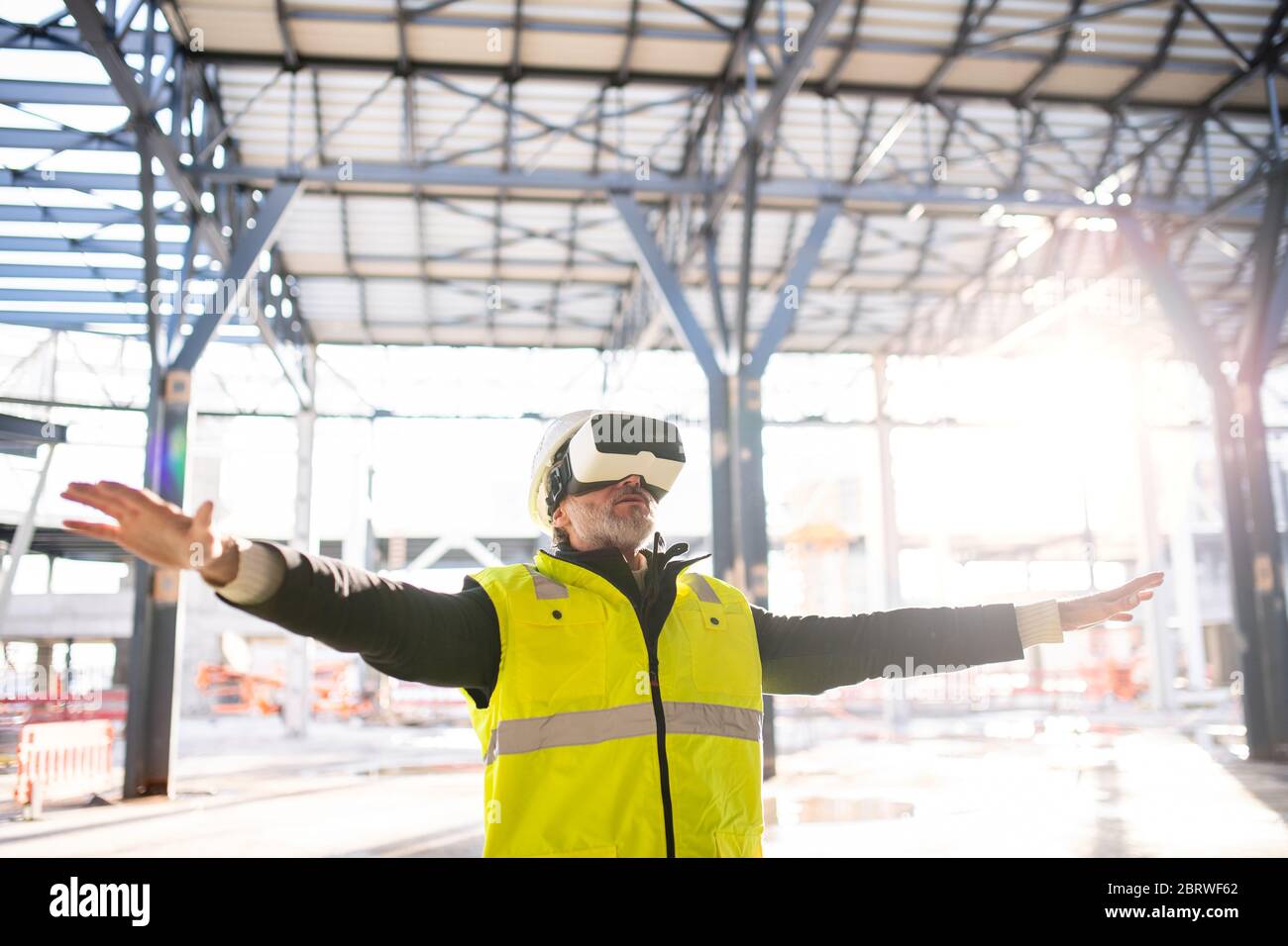 Man engineer using VR goggles on construction site. Stock Photo