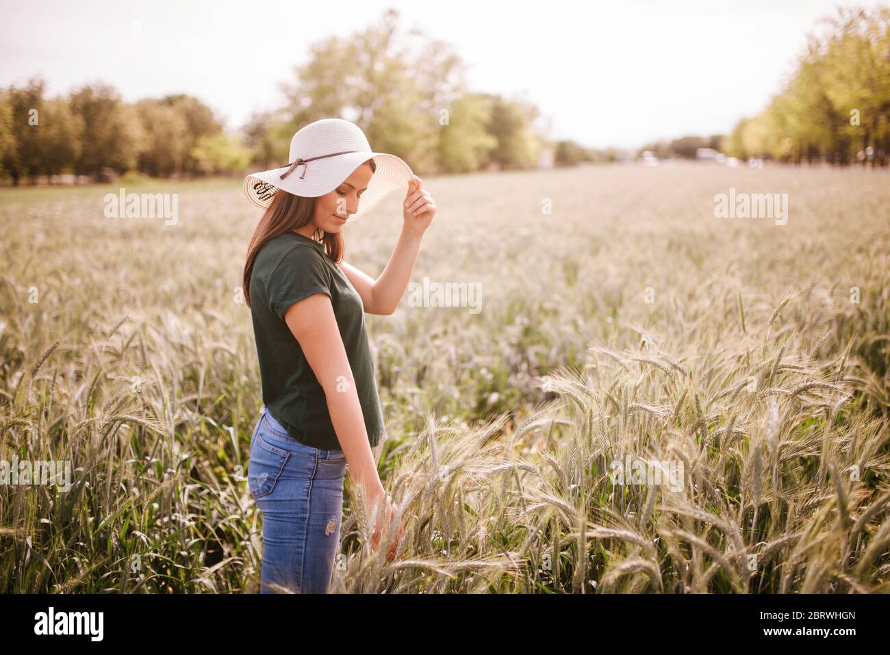 A beautiful attractive smiling caucasian woman with a straw hat in a ...