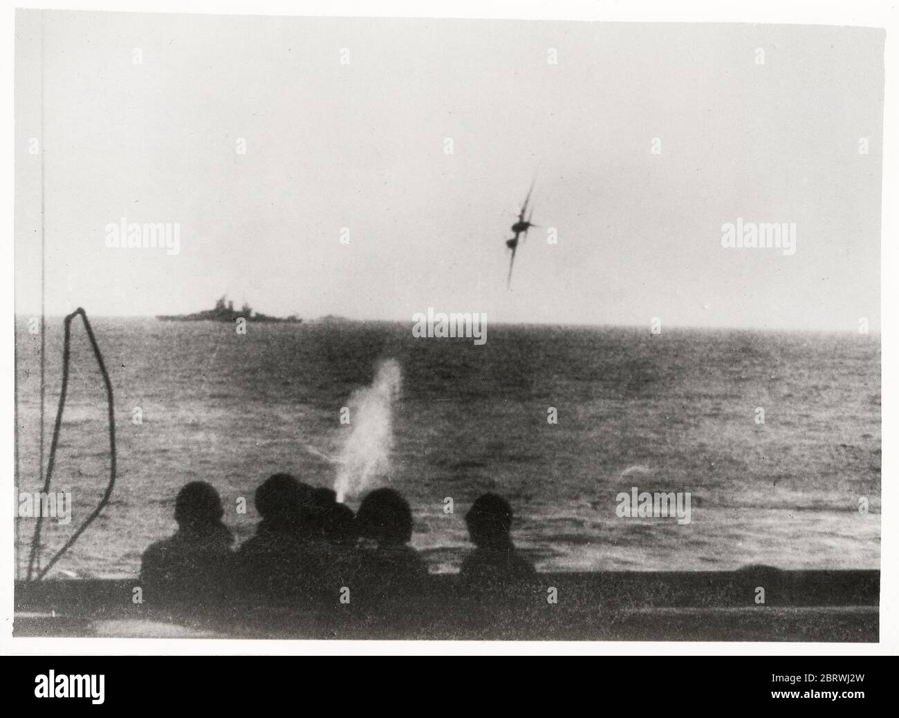 Vintage World War II photograph - Japanese suicide kamikaze attack on an American battleship in the Pacific. The plane was brought down just short of the ship. Stock Photo