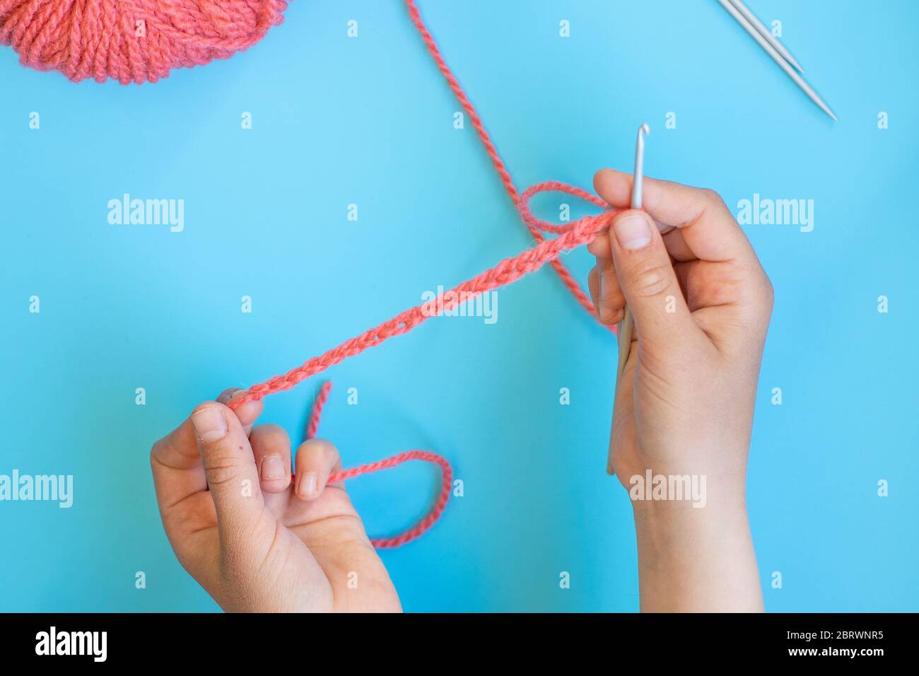Step-by-step instructions for children how to crochet a bracelet from yarn Stock Photo
