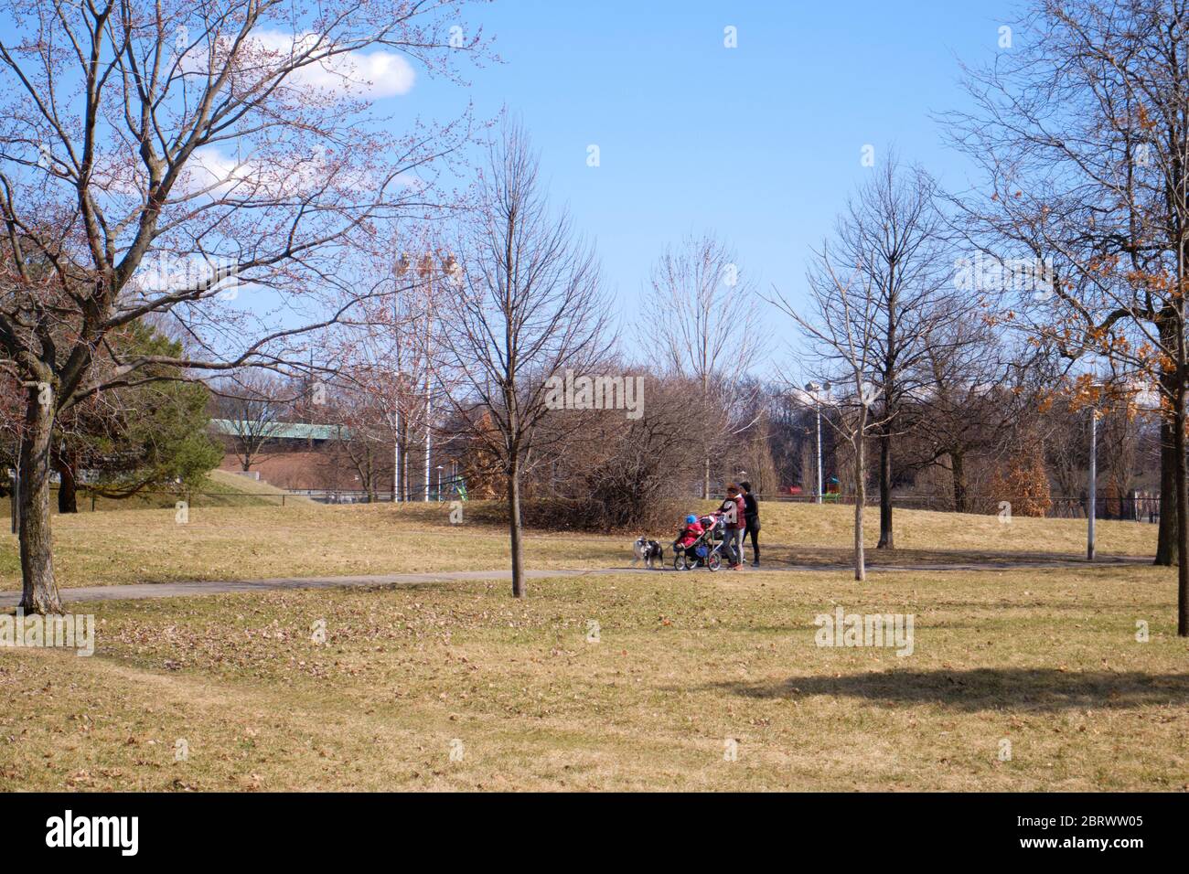 Quiet park in Montreal, with a couple of mothers walking  in early spring Stock Photo