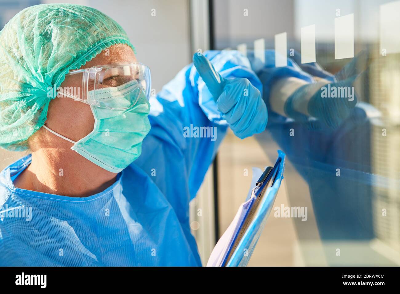 Nursing staff or containment scout with list for contact tracking gives hand signals in front of