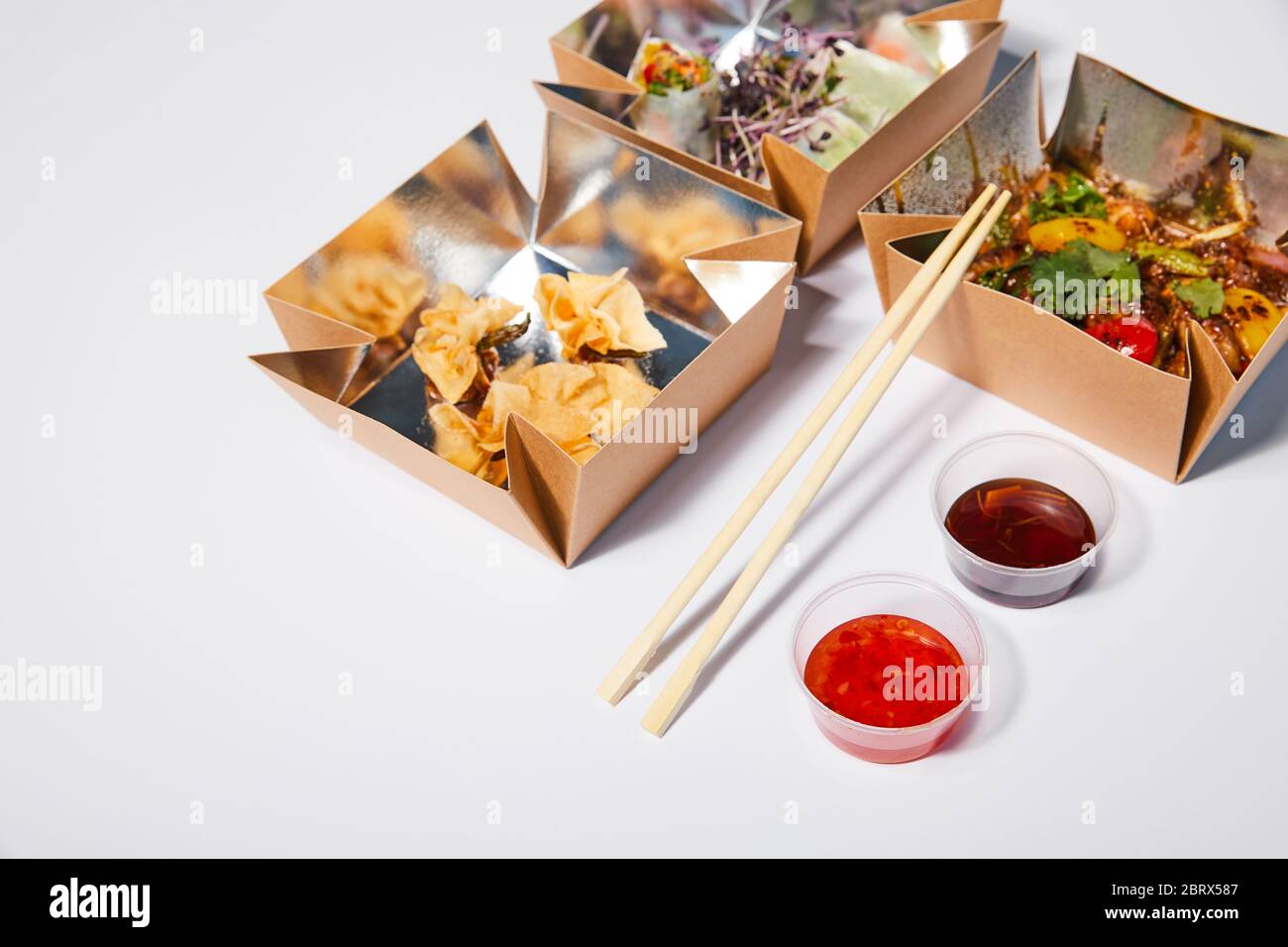 sauces and chopsticks near takeaway boxes with prepared chinese food on white Stock Photo Alamy