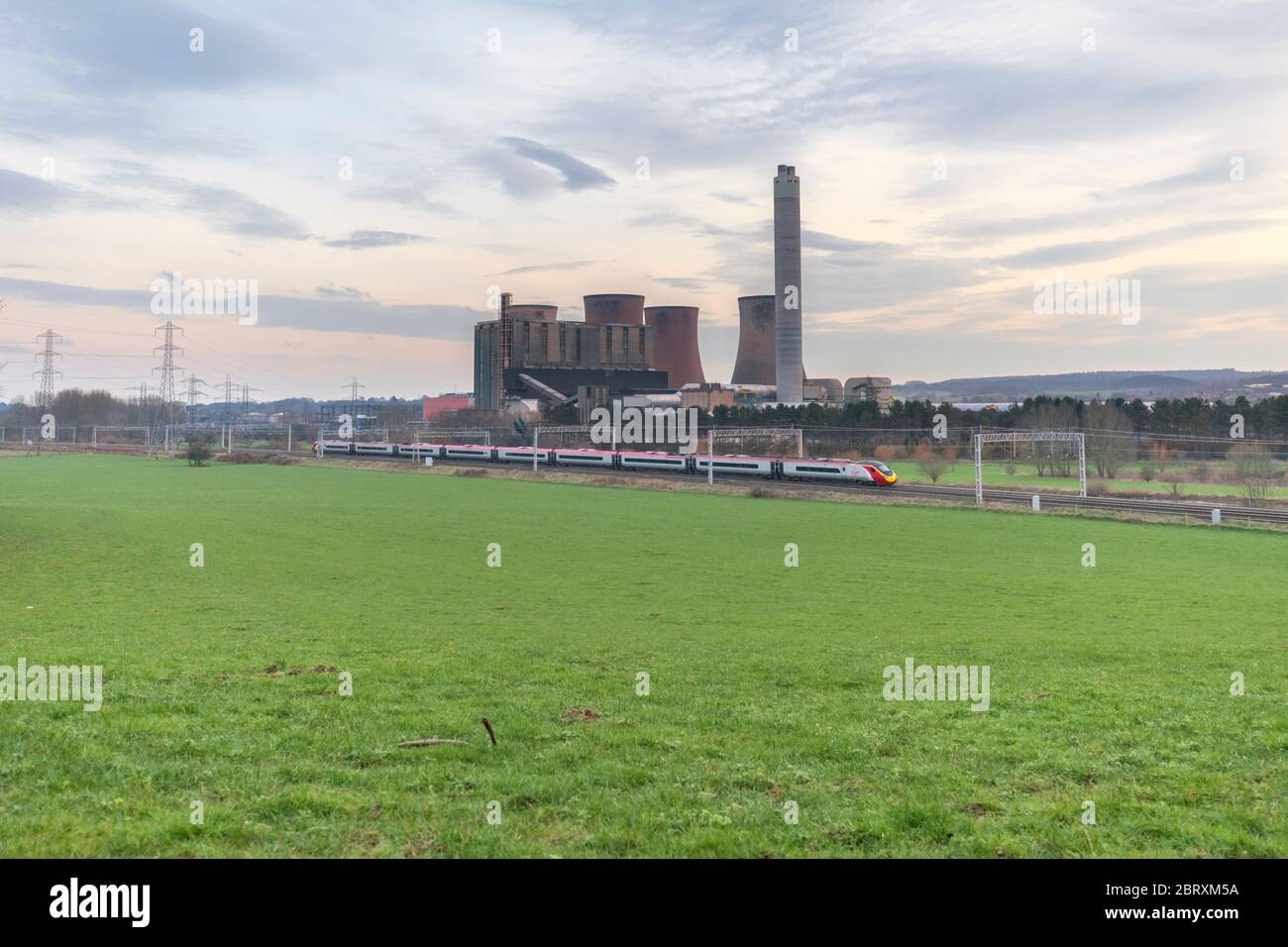A virgin Trains west coast  Pendolino passes Rugeley power station on the west coast mainline. Stock Photo