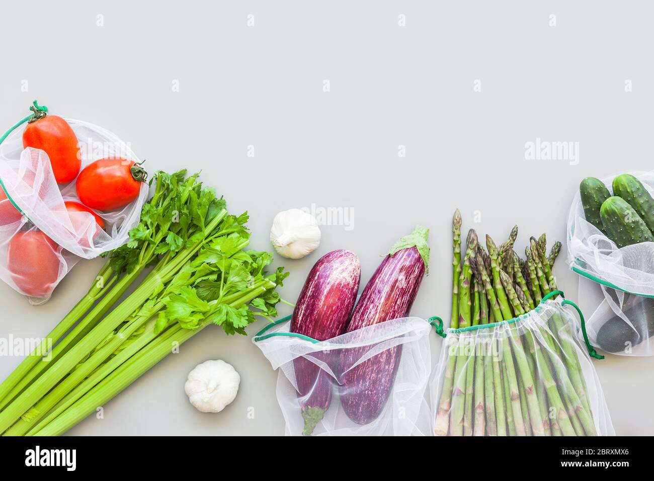 Fresh organic vegetables in eco reusable produce shopping bags flat lay ...