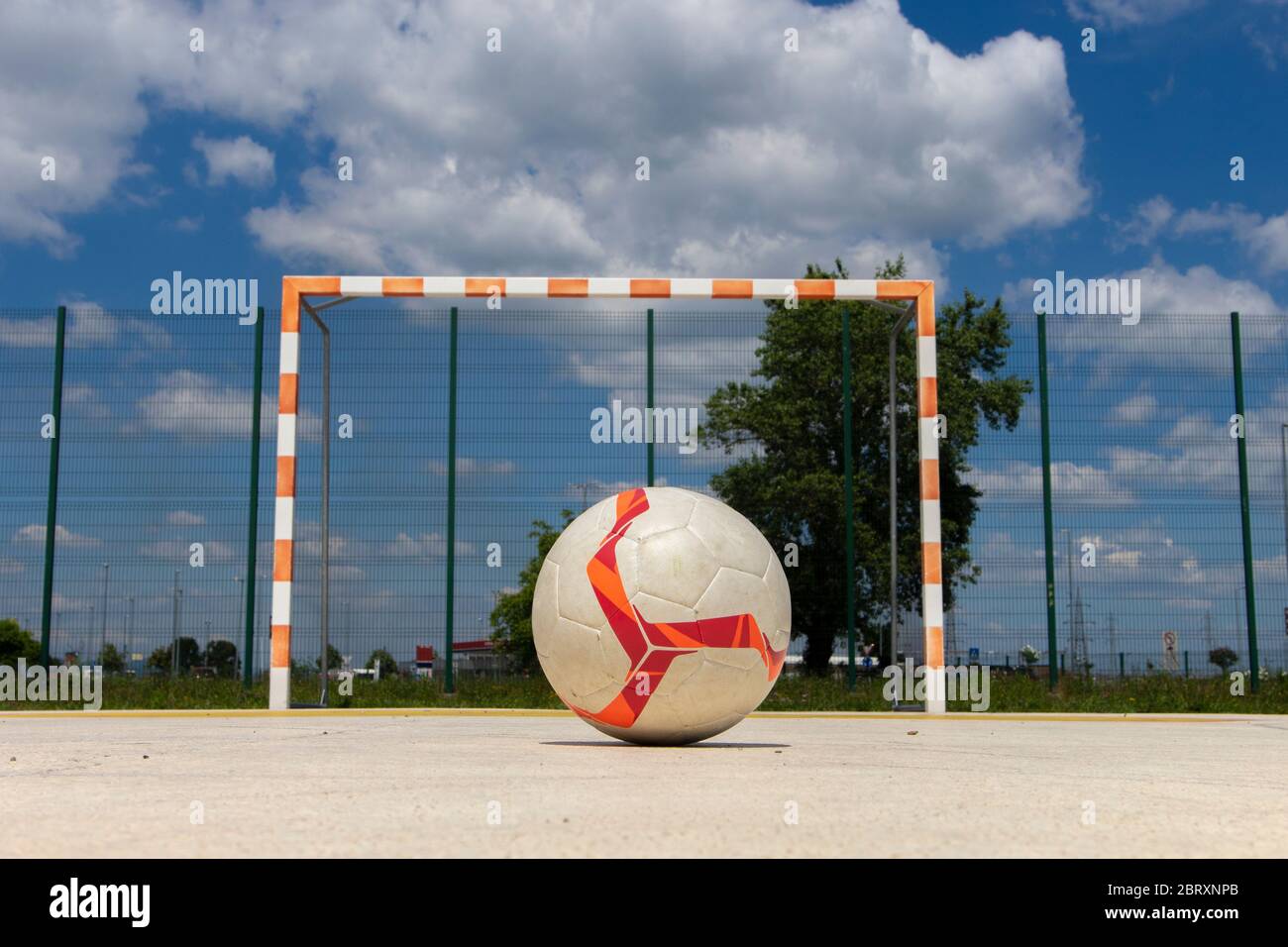 Soccer ball placed on the penalty spot in front of empty goal posts on outdoor playgroun, under