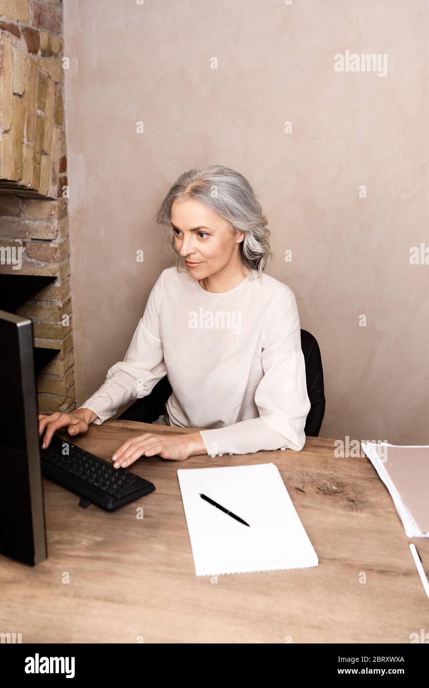 mature woman typing on computer keyboard at home Stock Photo - Alamy