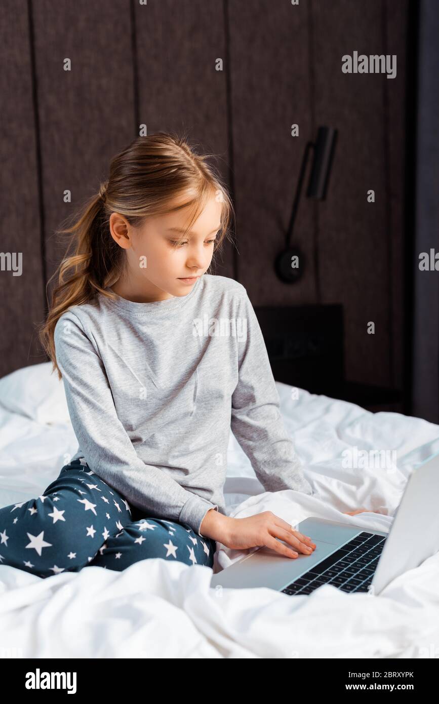 kid using laptop with e-learning in bedroom Stock Photo