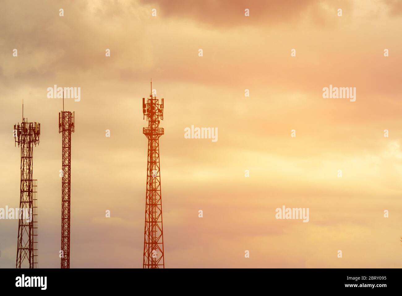 Silhouette signal antenna tower at sunset sky background. Silhouette the mobile communication antennas in evening sky Stock Photo