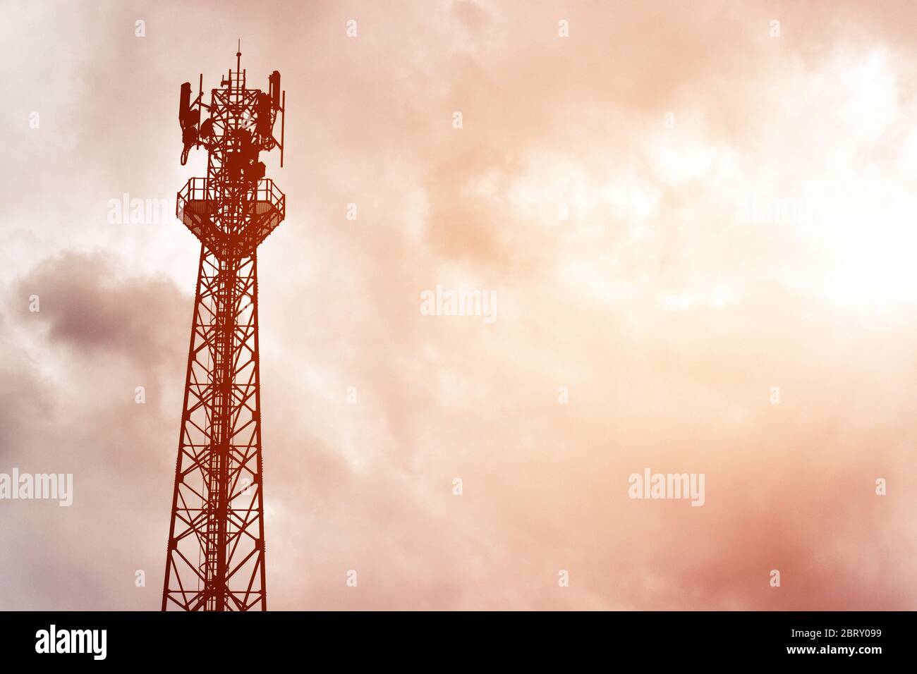 Silhouette signal antenna tower at sunset sky background. Silhouette the mobile communication antennas in evening sky Stock Photo