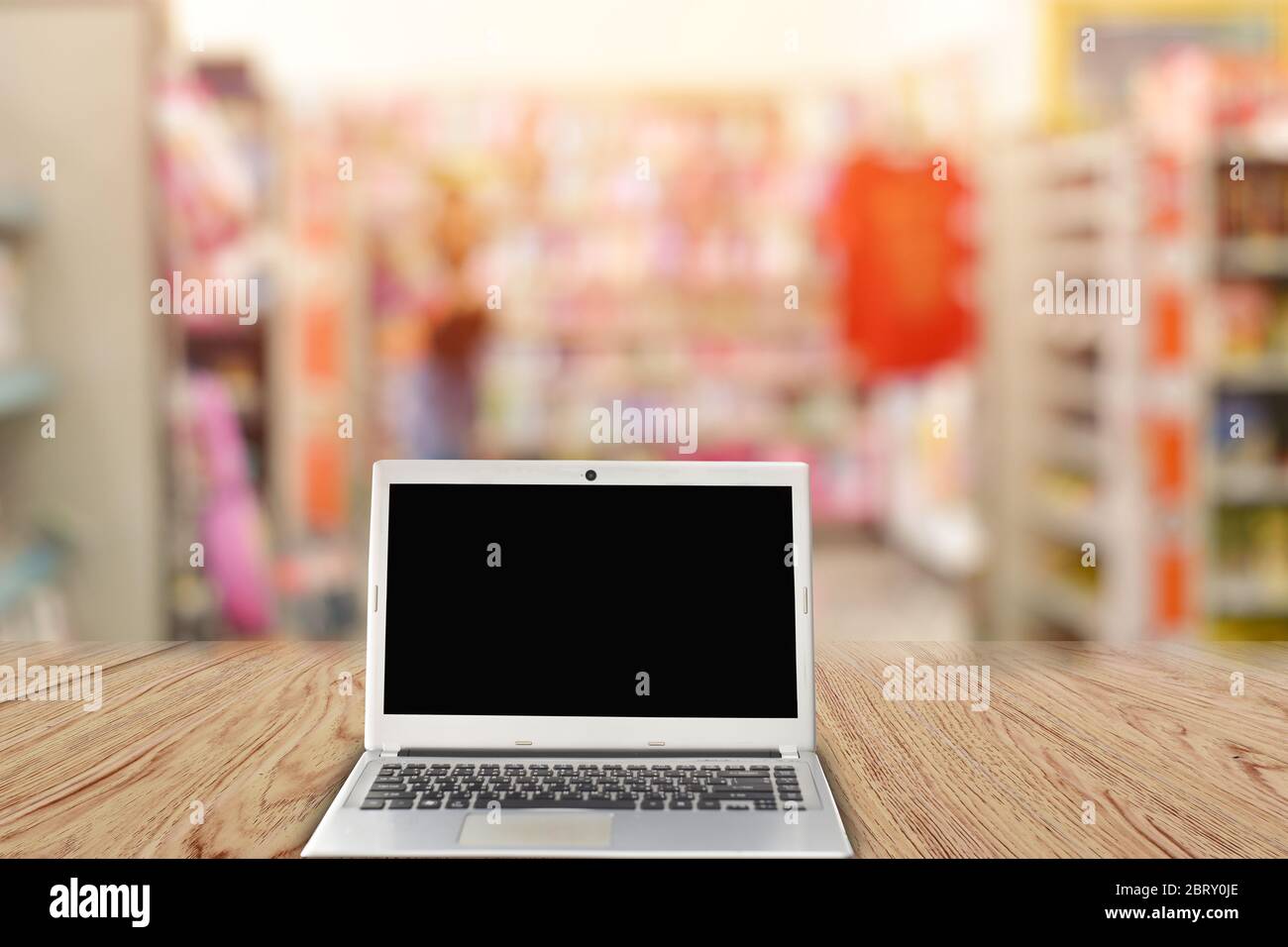 Laptop with blank screen on table, Blurred background at light bokeh. Stock Photo