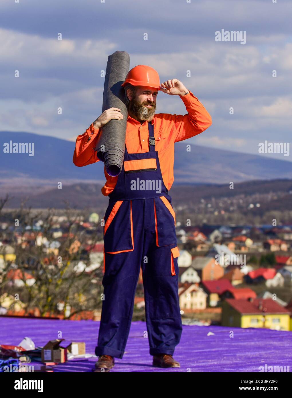 Flat roof installation. Man hard hat working outdoor landscape