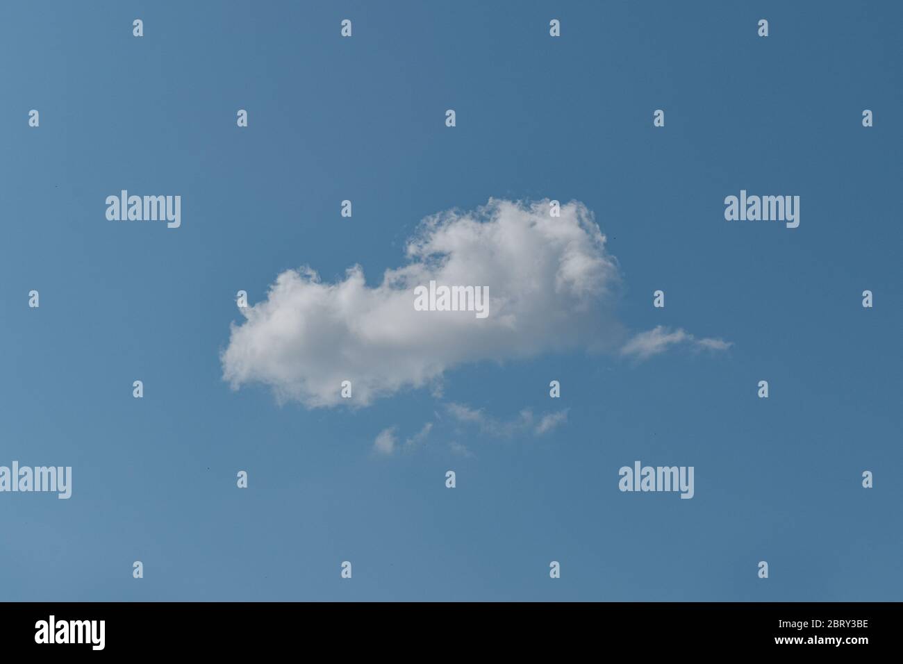 Single white cloud on blue sky background. Stock Photo