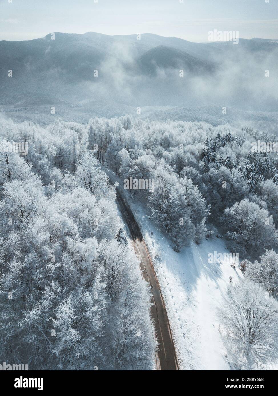 Aerial drone view of road in idyllic winter landscape. Street running through the nature from a birds eye view Stock Photo