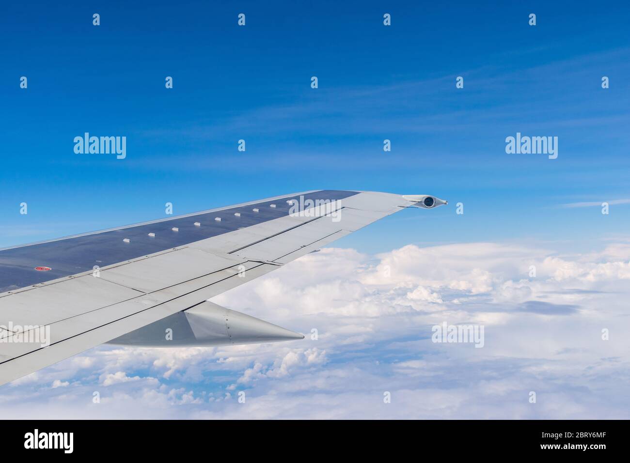 Wing of a plane flying above the clouds Stock Photo - Alamy