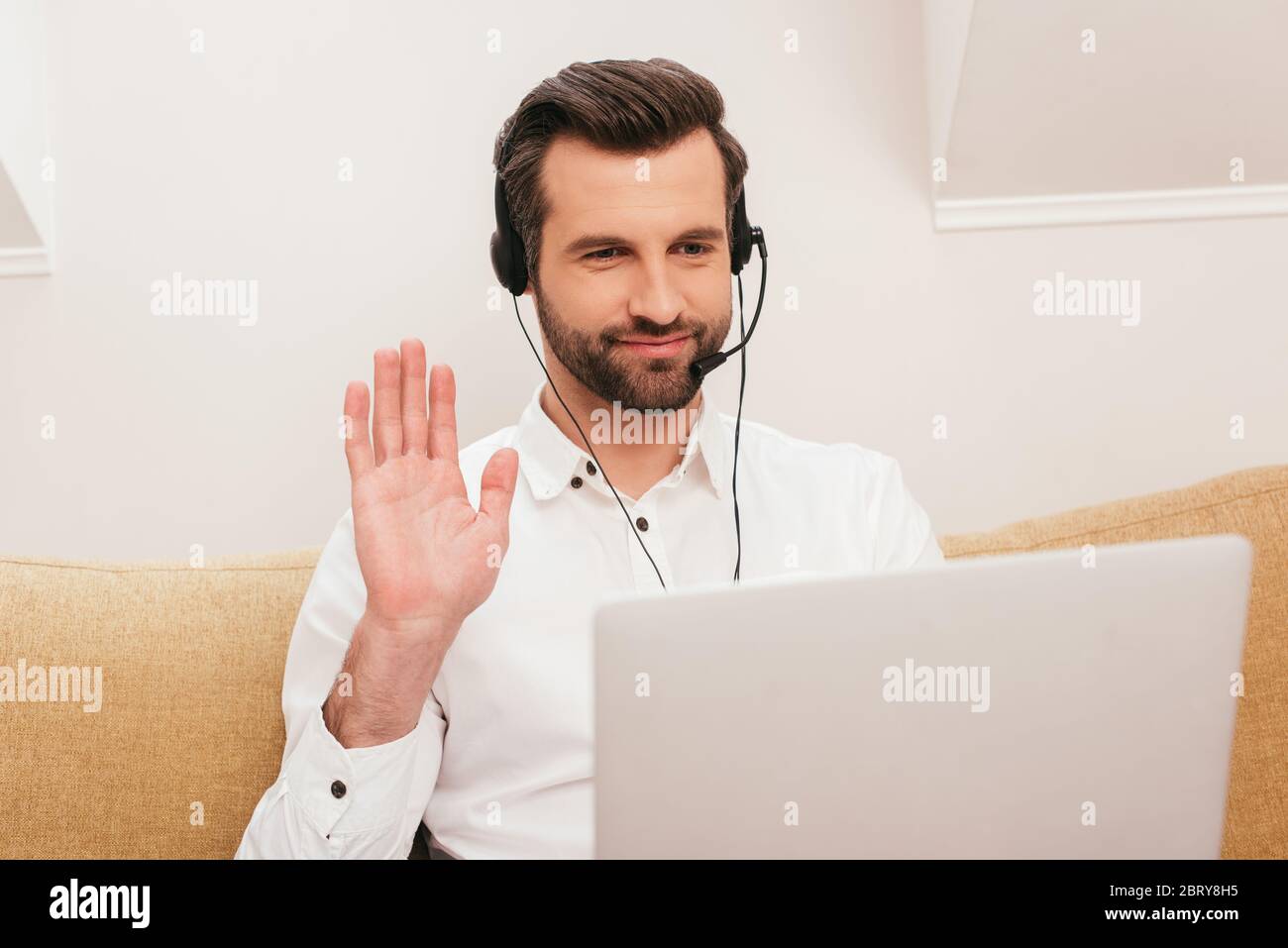 Selective focus of smiling freelancer in headset having video call on ...