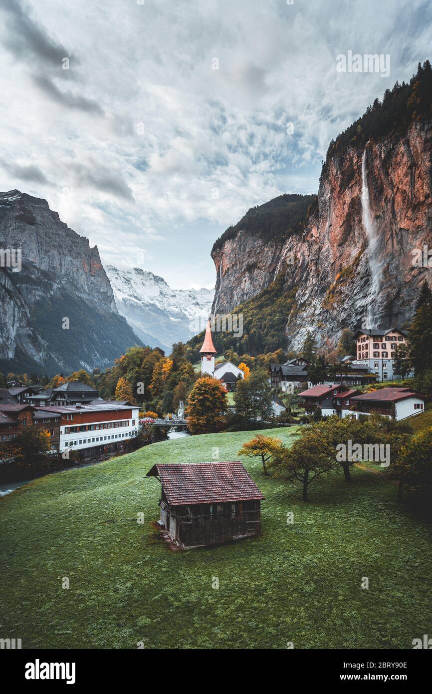 Amazing touristic alpine village with famous church and Staubbach waterfall, Lauterbrunnen, Switzerland, Europe Stock Photo