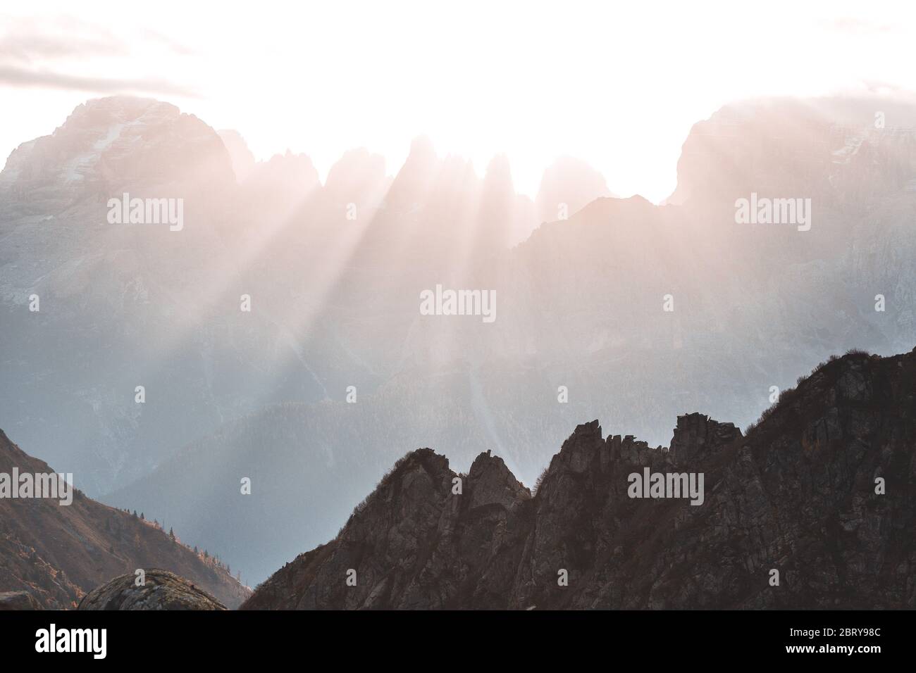Sun rays passing through high mountains with illuminated peaks and stones. Beautiful landscape in Val Nambrone, Trentino, Italy Stock Photo