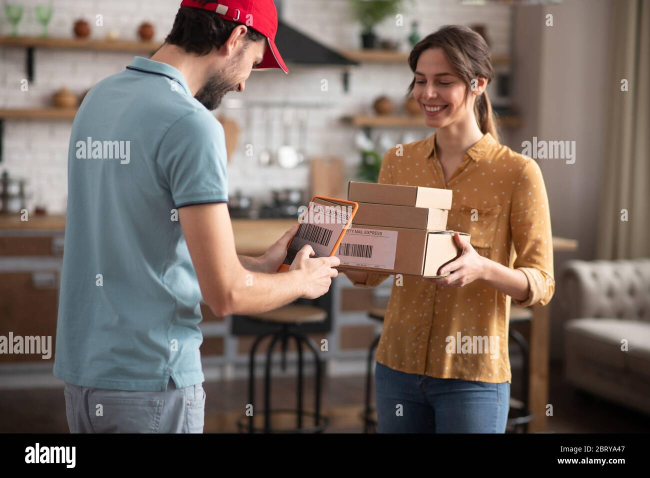Female customer receiving boxes from a delivery person Stock Photo - Alamy