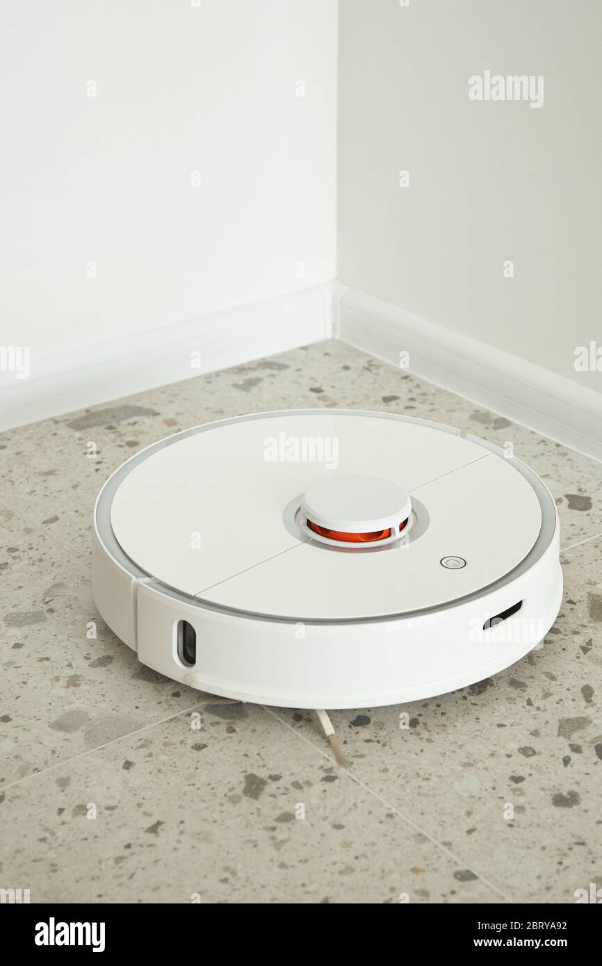 robotic vacuum cleaner washing floor tiles near white walls Stock Photo Alamy