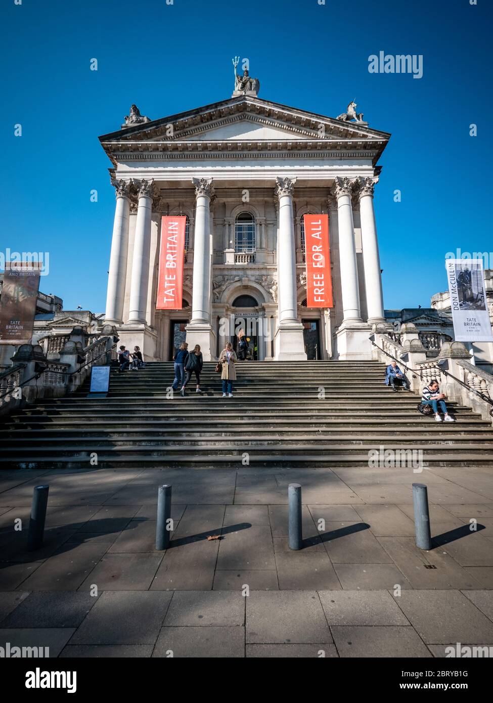 The Tate Britain museum and gallery on Millbank, Westminster, with visitors milling around the entrance and sitting on the stairs. Stock Photo