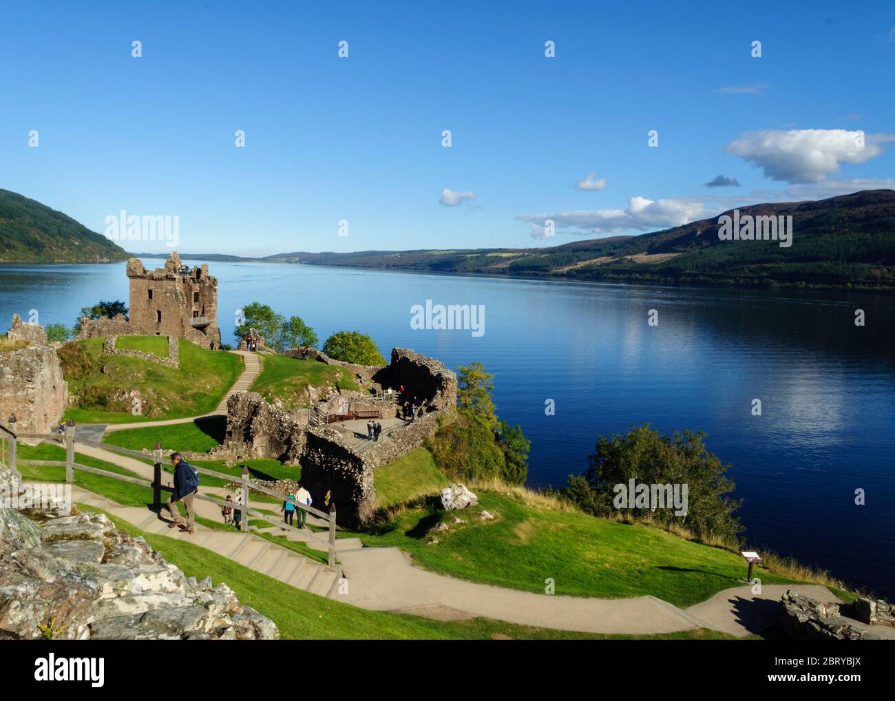 Tourists sightseeing at Urquhart Castle and Loch Ness on a sunny day Stock Photo
