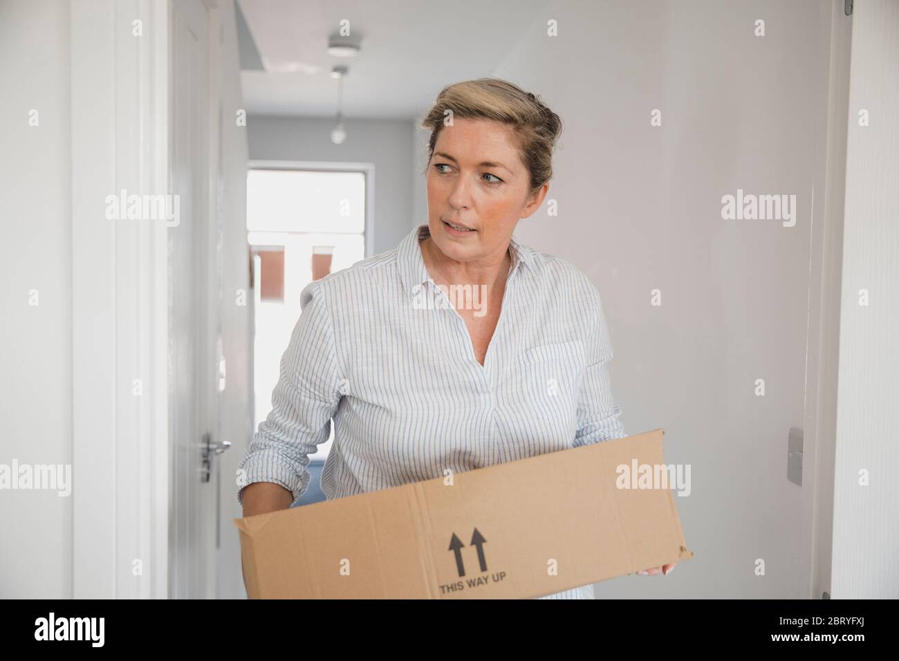 Mature woman is moving boxes in to her new home. Stock Photo