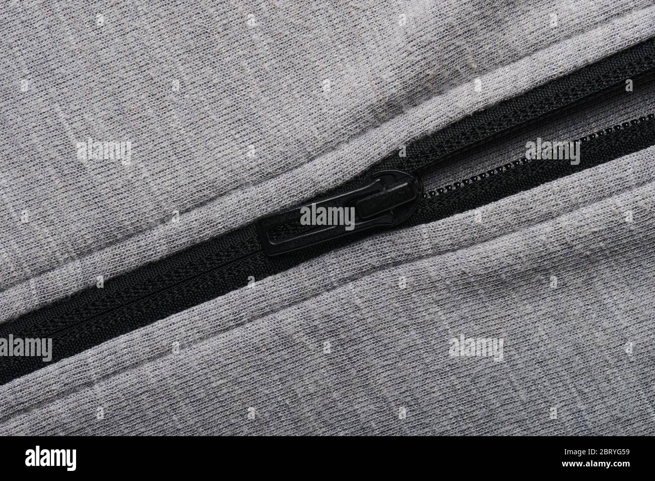 Black zipper on grey textile background macro close up view Stock Photo