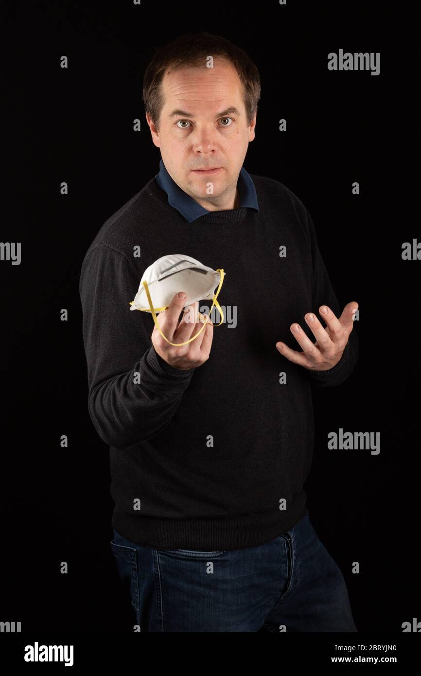 A man holding a medical face mask Stock Photo - Alamy