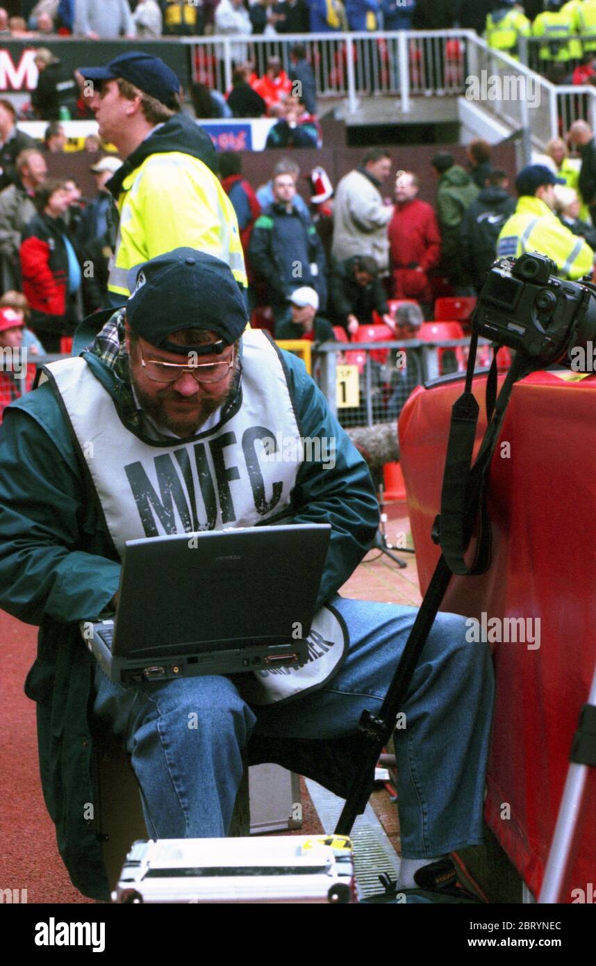A sports news photographer reviewing photos in half-time break during Manchester United vs Leeds United match in Premiership (Premier League) 2000-01 in Old Trafford stadium, Manchester, England, on Saturday, 21 Oct 2000. Archival photo. Stock Photo