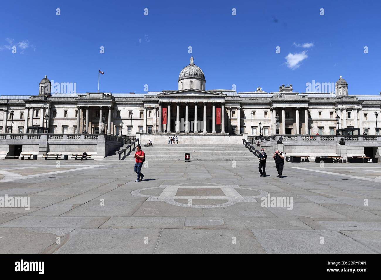 People walk across Trafalgar Square, London, after the introduction of measures to bring the country out of lockdown. Stock Photo