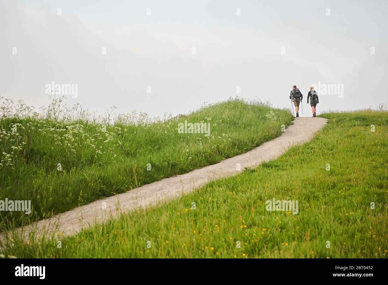 Two people walking along a coastal path Stock Photo