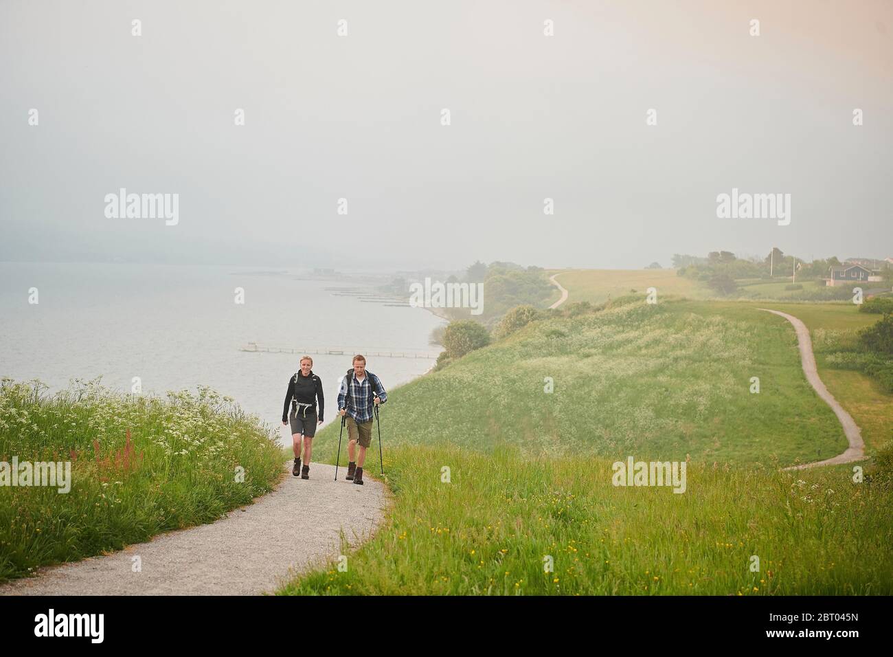 Two people walking along a coastal path Stock Photo
