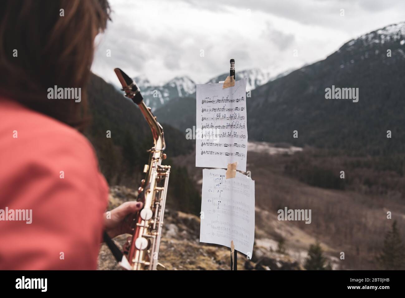 Woman standing on a mountain in the Squamish Valley, British Columbia, Canada, playing the saxophone. Stock Photo
