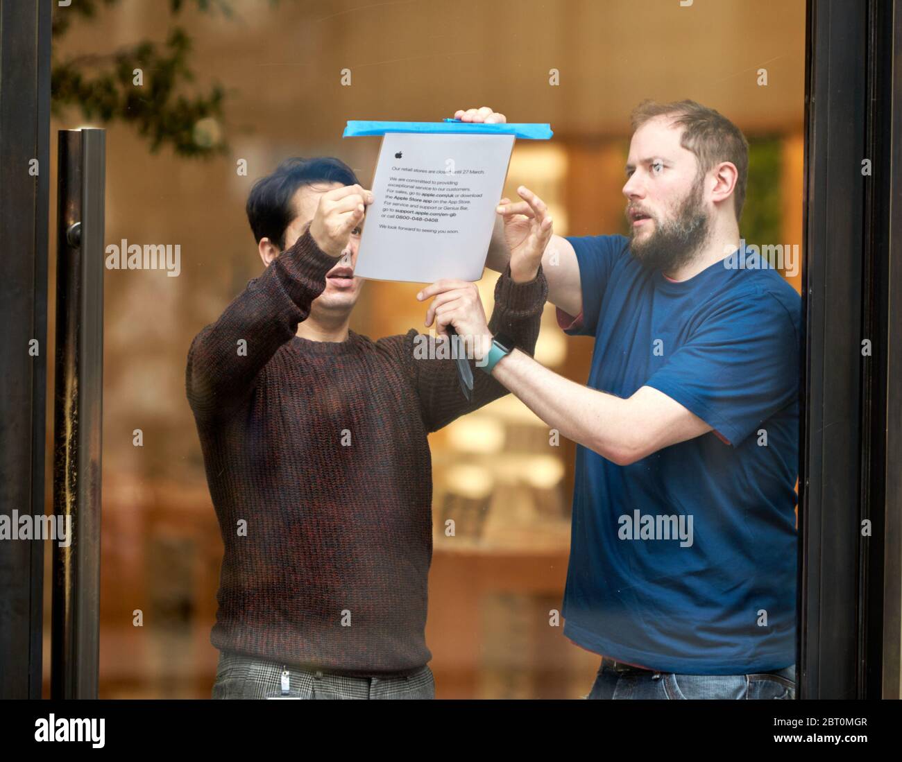 Apple store employees put up notices informing customers that the shop on Regent Street, London, will be shut until the 27 March. The company is closing all its retail outlets outside of China due to the spread of Coronavirus. Stock Photo